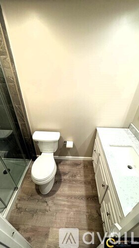 A white toilet sits in a bathroom next to a sink.