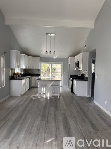 A spacious kitchen with white cabinets and a large island.
