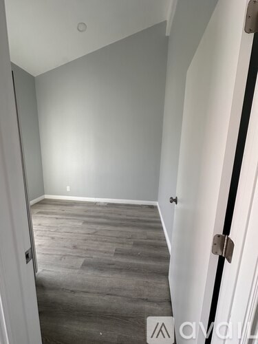 A hallway with a wooden floor and white walls.