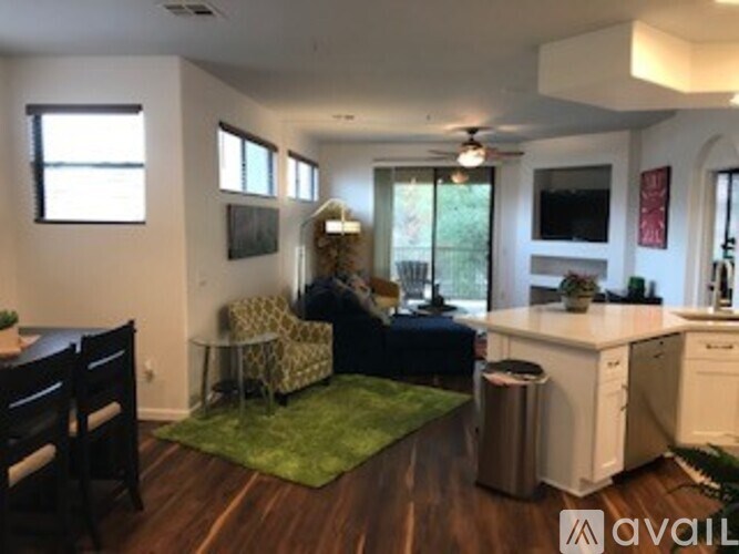A living room with a couch, chairs, and a dining table.