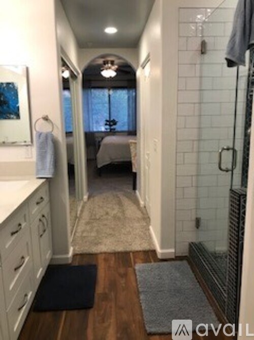 A bathroom with a walk-in shower and a towel hanging on the wall.
