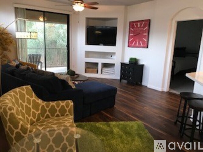 A living room with a couch, chair, and television.
