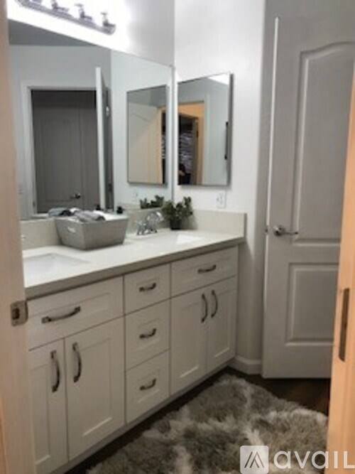 A bathroom with a white vanity and a mirror above it.