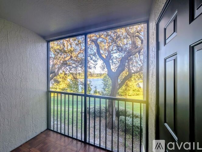 A balcony with a view of a tree and a body of water.