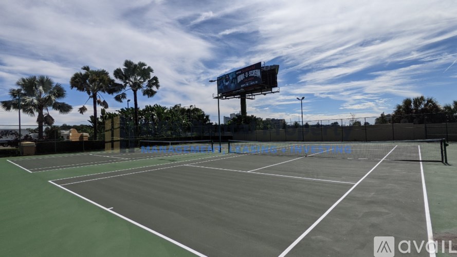 A tennis court with a blue billboard above it.