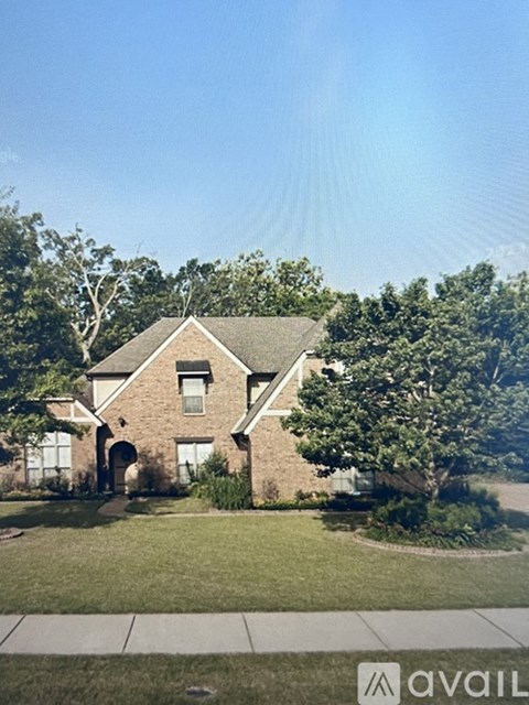 A house with a large front yard and a driveway in front.