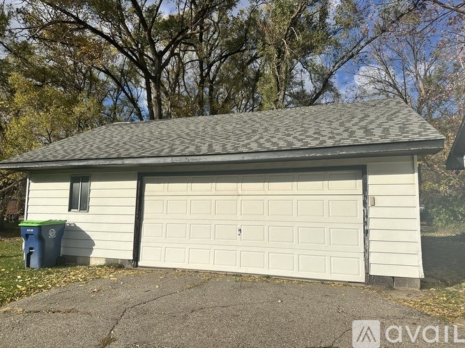 A two-car garage with a white door and a grey roof.