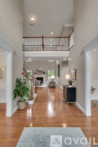A large open living room with a staircase and a potted plant.