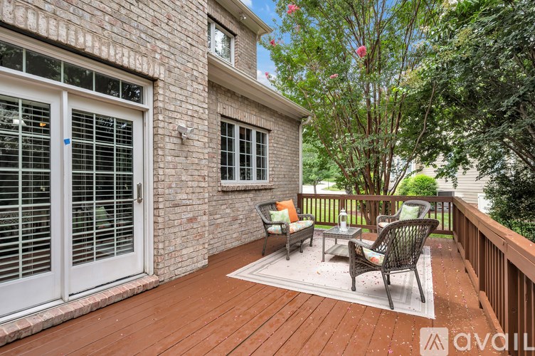A patio with a table and chairs is on a brick building.