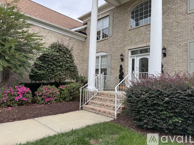 A brick building with a white column and steps leading up to the door.