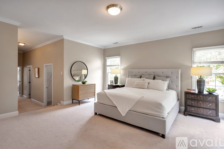 A bedroom with a large bed, a dresser, and a mirror.