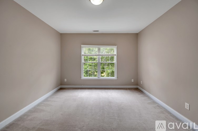 A room with a window showing greenery outside.