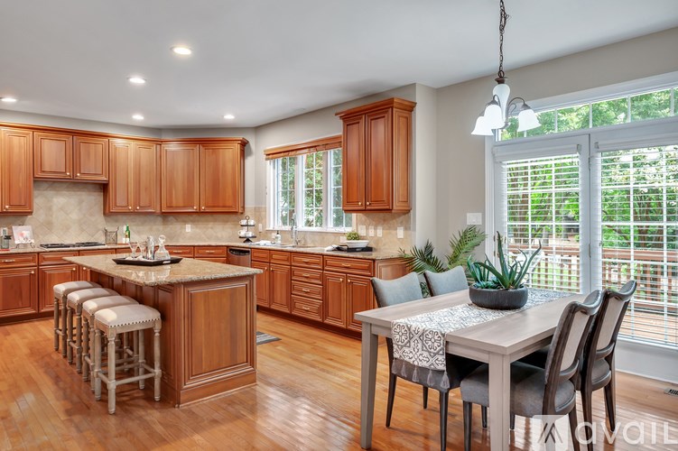 A kitchen with wooden cabinets and a marble countertop.