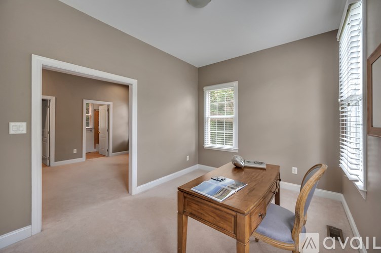 A room with a desk and a chair in it.