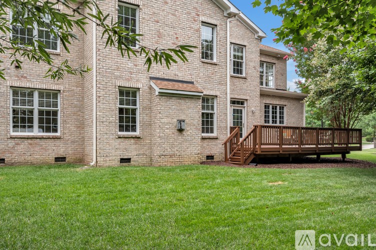 A brick house with a wooden deck in front.