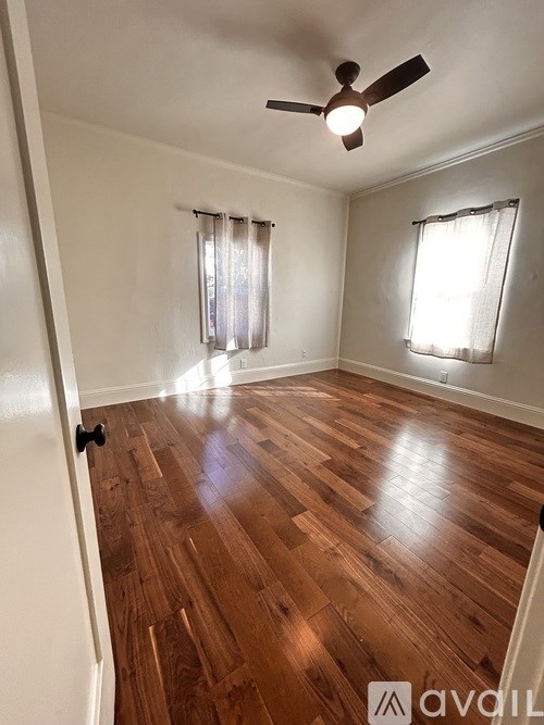 A room with wooden flooring and a ceiling fan.
