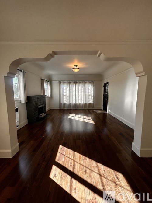 A sunny day with sunlight coming through the window and casting a shadow on the wooden floor.