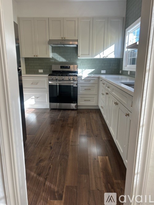 A kitchen with white cabinets and a black stove top oven.