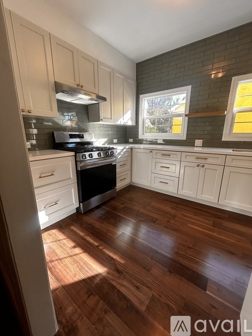 A kitchen with wooden floors and white cabinets.