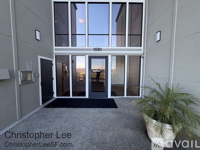 The image shows a front door entrance with a glass door and a black mat on the floor.