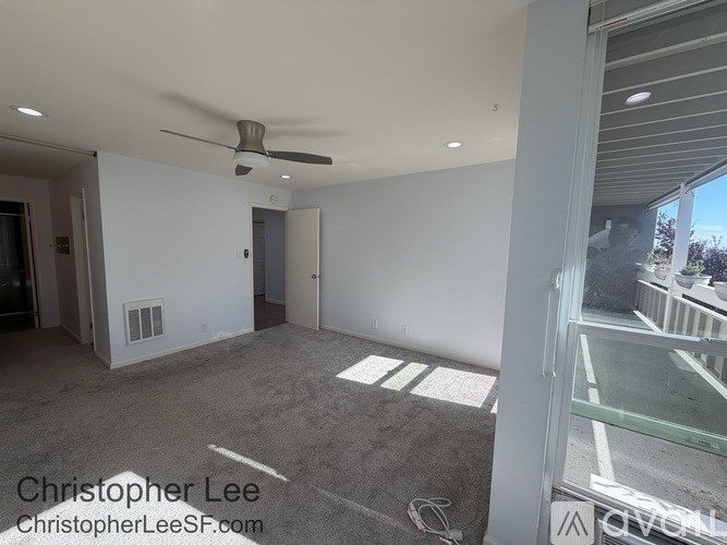 A room with a ceiling fan and a door.