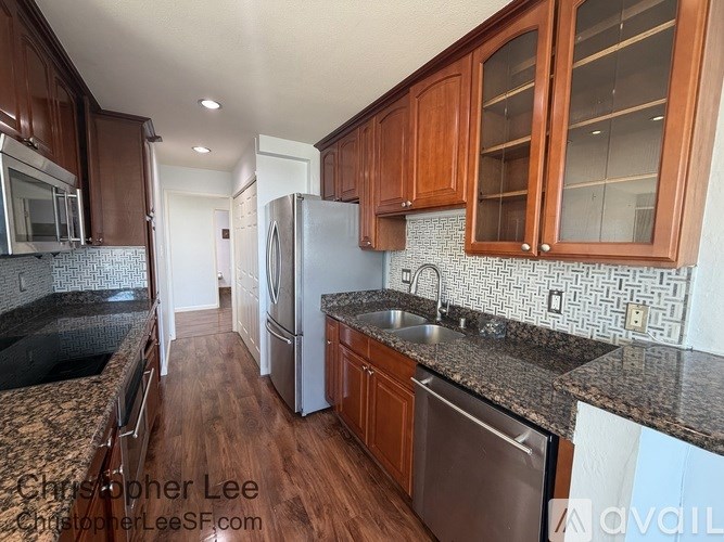 A kitchen with wooden cabinets and a stainless steel refrigerator.