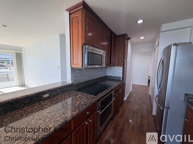 A kitchen with brown cabinets and a granite countertop.