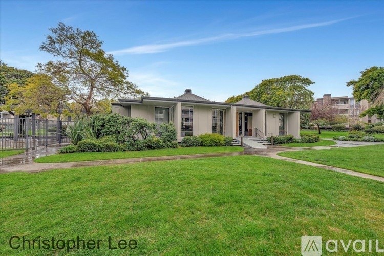 A house with a green lawn and trees in the background.