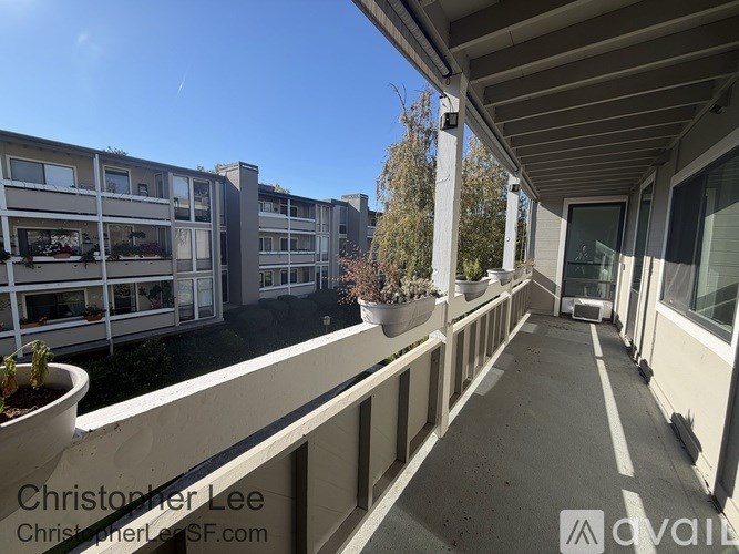A balcony with a view of apartment buildings and trees.