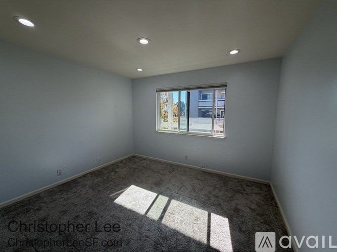 A room with a window and a carpet on the floor.