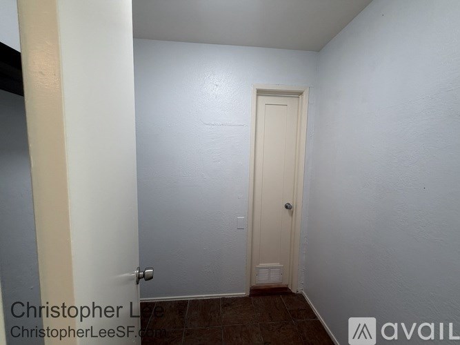 A white door in a room with a brown floor.