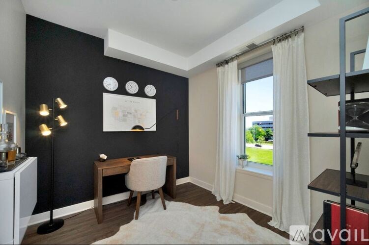 A room with a desk and chair, a window with curtains, and a shelf with books.
