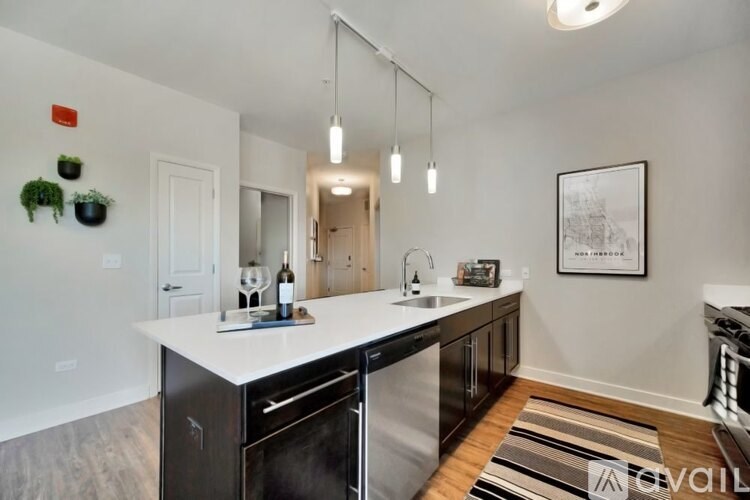 A kitchen with a white countertop and a fridge with a black handle.