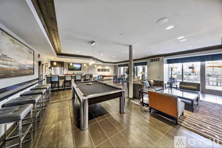 A room with a pool table and a bar area.