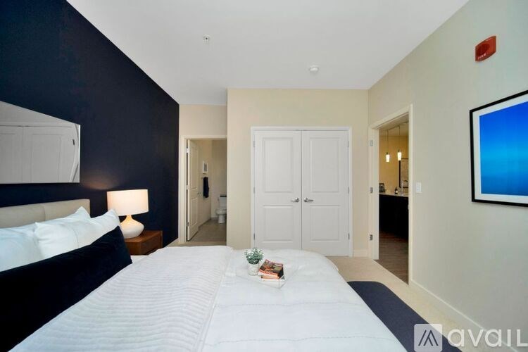 A bedroom with a large bed and a painting on the wall.