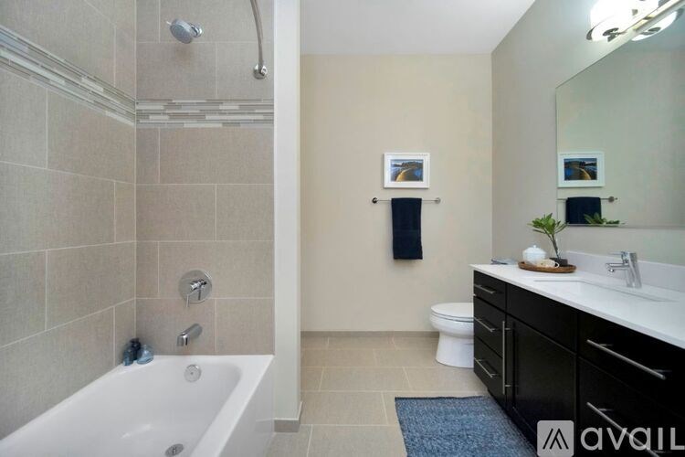 A bathroom with a white tub and a sink with a mirror above it.
