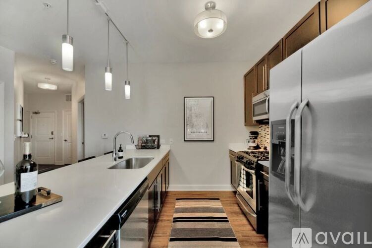 A modern kitchen with a white countertop and stainless steel appliances.