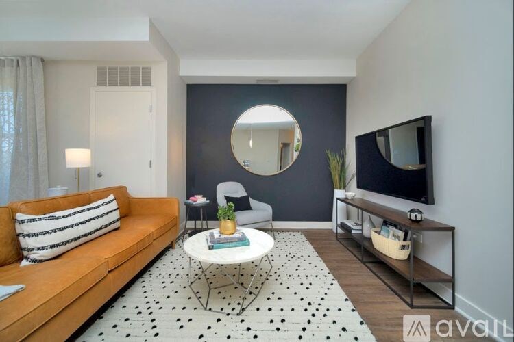 A living room with a sofa, a coffee table, a mirror, and a television.