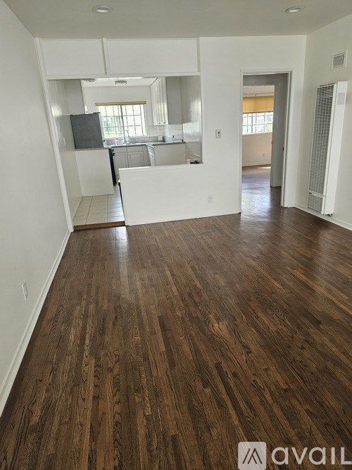 A room with wooden flooring and white walls.