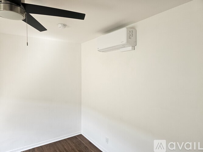 A room with a ceiling fan and air conditioner unit.