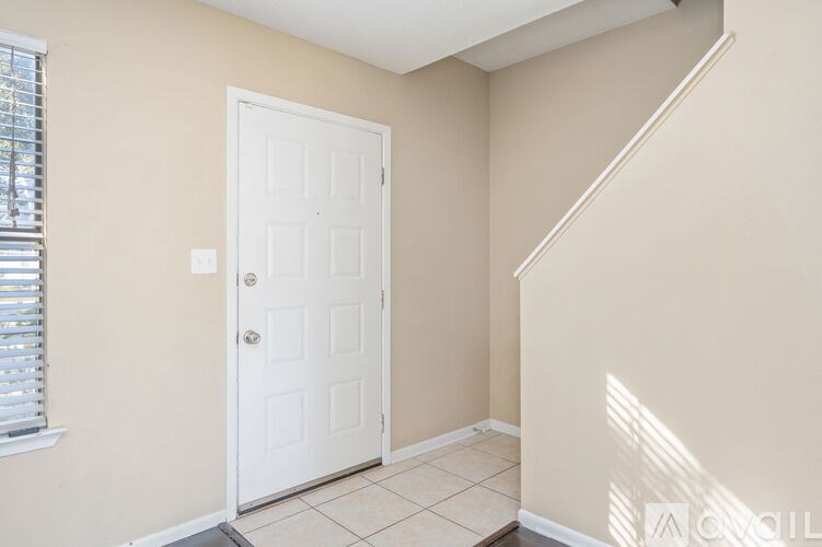 A white door is in a room with beige walls.
