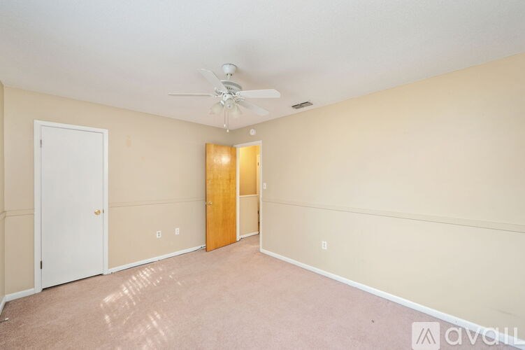 A room with a ceiling fan and two doors.