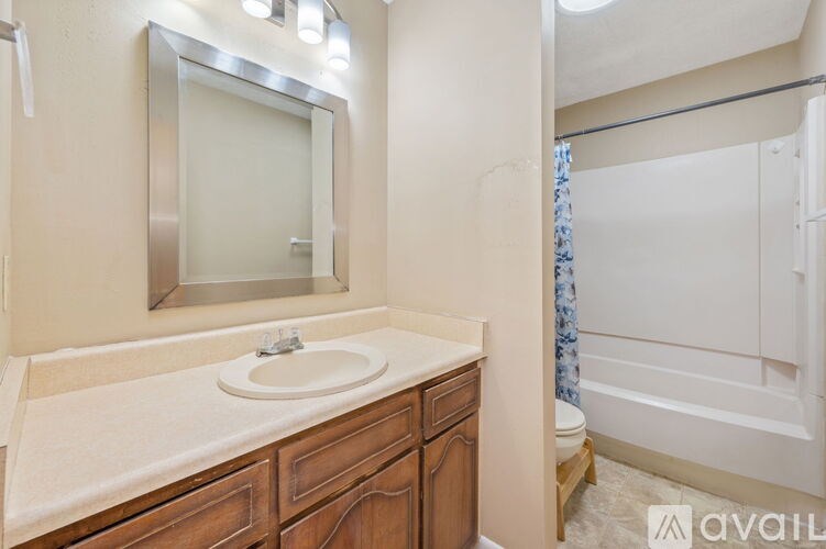 A bathroom with a sink, mirror, and bathtub.