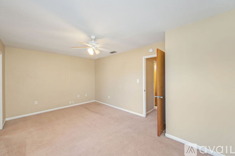 A room with a ceiling fan and a door.