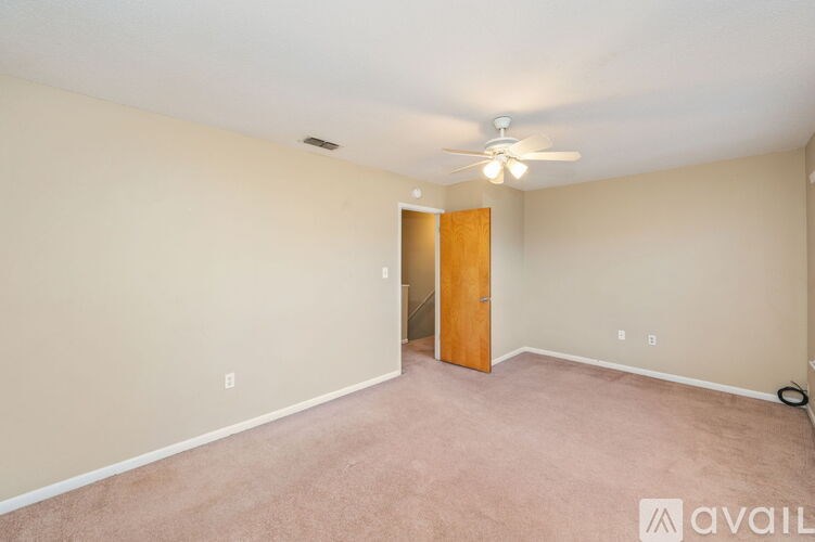 A room with a ceiling fan and a door.