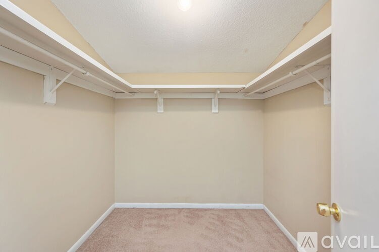 A room with a carpeted floor and a white door.