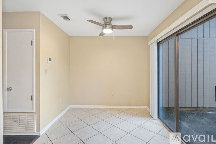A room with a ceiling fan and a door with a window.