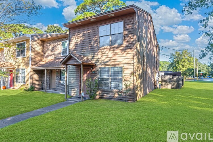 A wooden house with a green lawn in front.