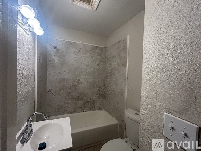 A bathroom with a white sink and a bathtub.