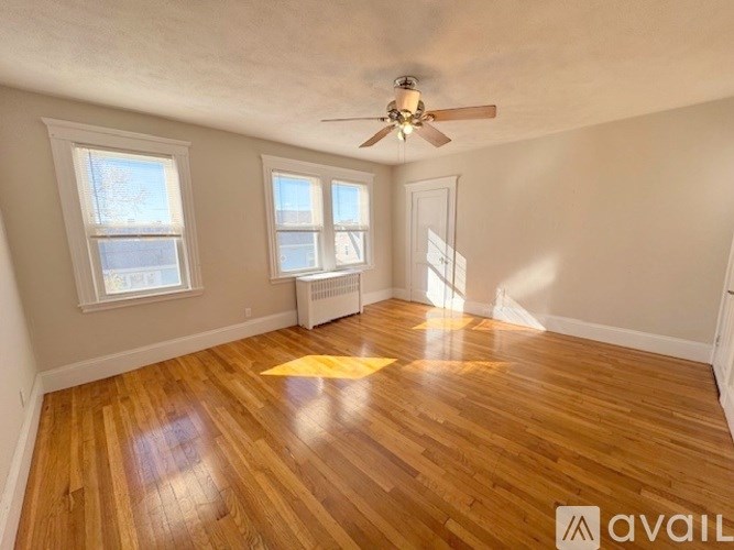 A room with wooden floors and a ceiling fan.
